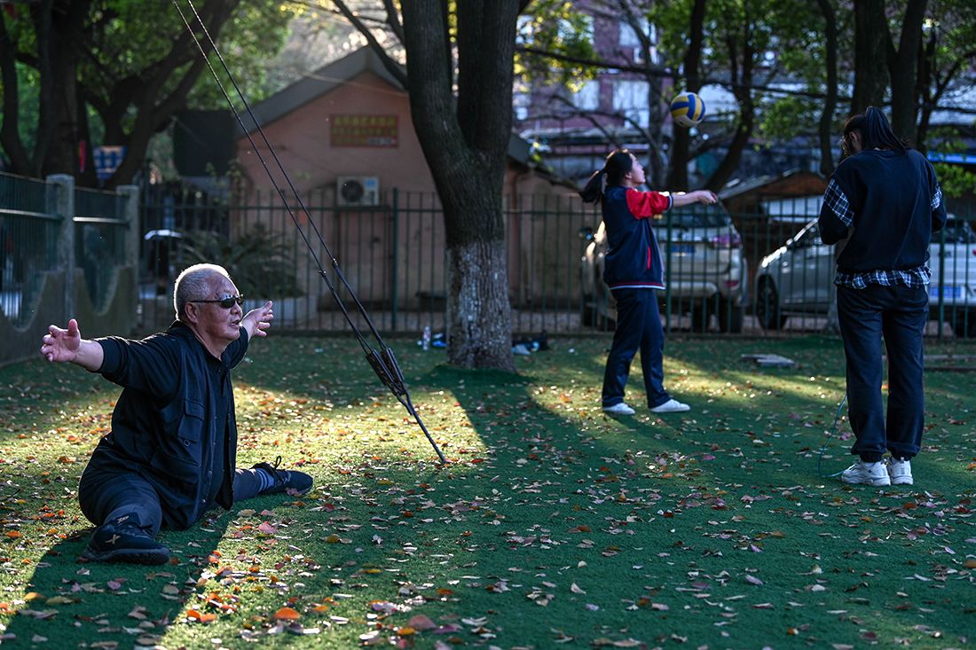 2021年3月25日，江西省南昌航空大学，一位老人在草地上做运动。
