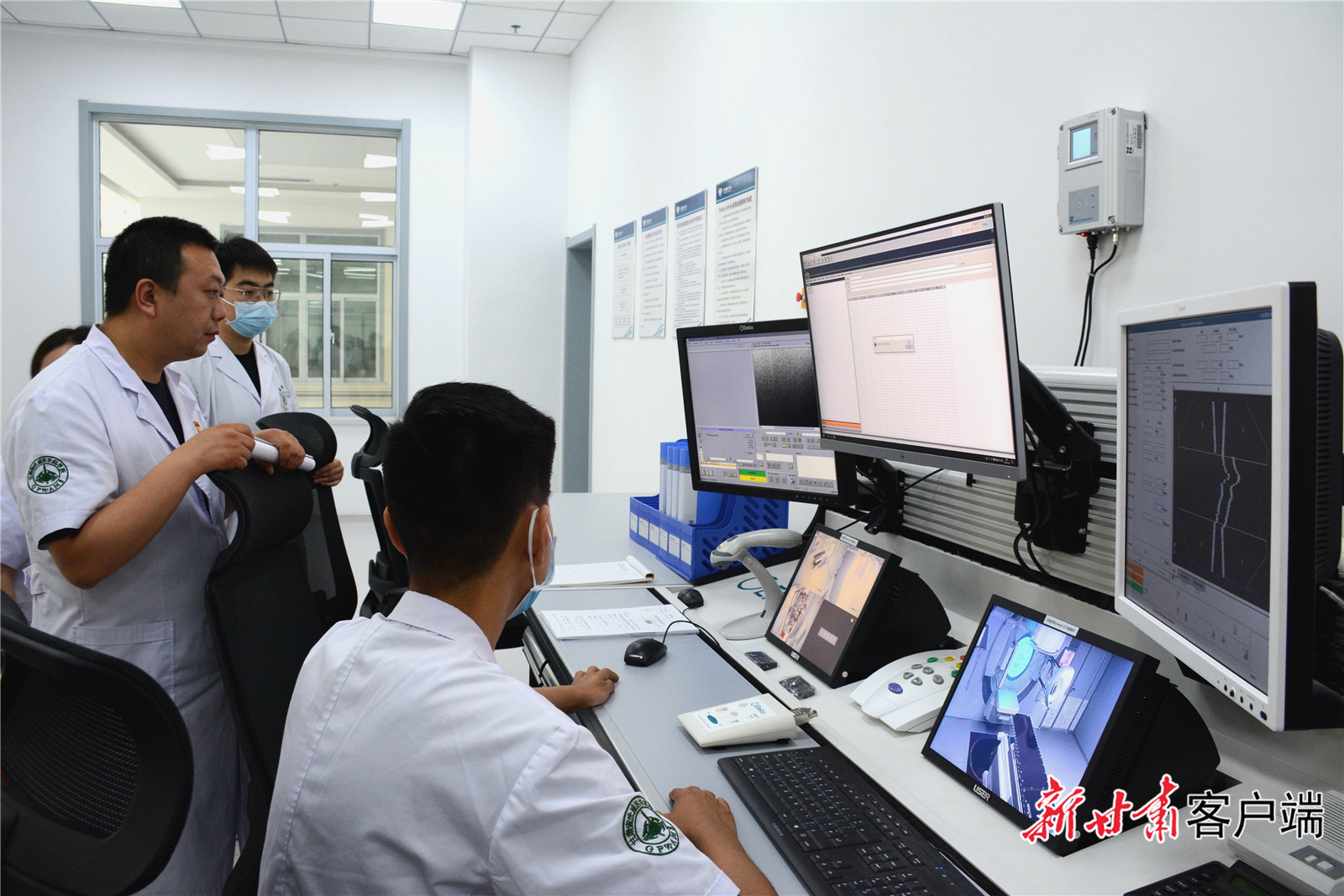 医生在四维影像引导医用直线加速器控制中心室交流 新甘肃&middot;甘肃日报记者 金奉乾 摄