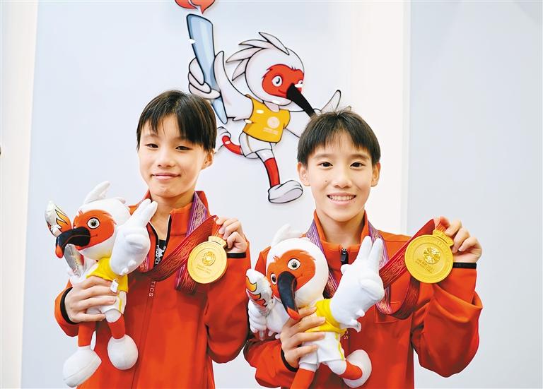 获得十四运会竞技项目"首金"的江苏选手阮莉俪(右)和吴心怡.