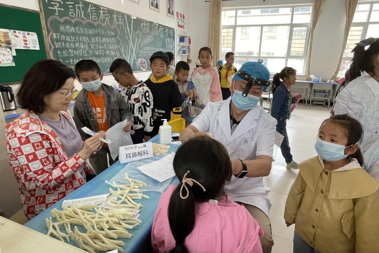 志愿者为孩子进行耳鼻喉科检查
