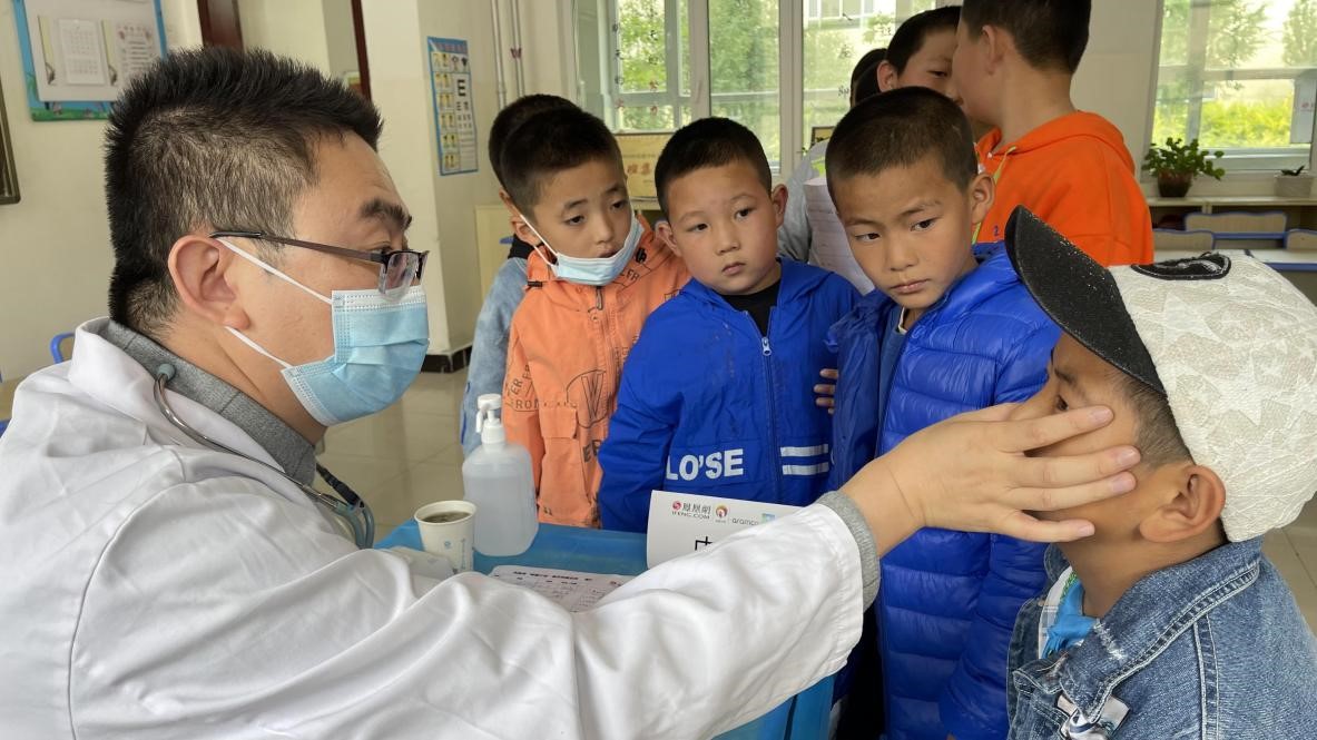 志愿者为孩子进行内科检查