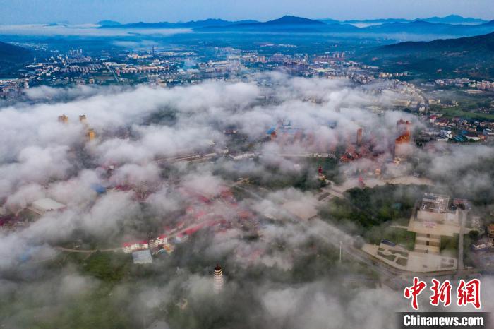 7月16日清晨，江西省瑞金市上空雨后出现平流雾，城市若隐若现。　马刚 摄