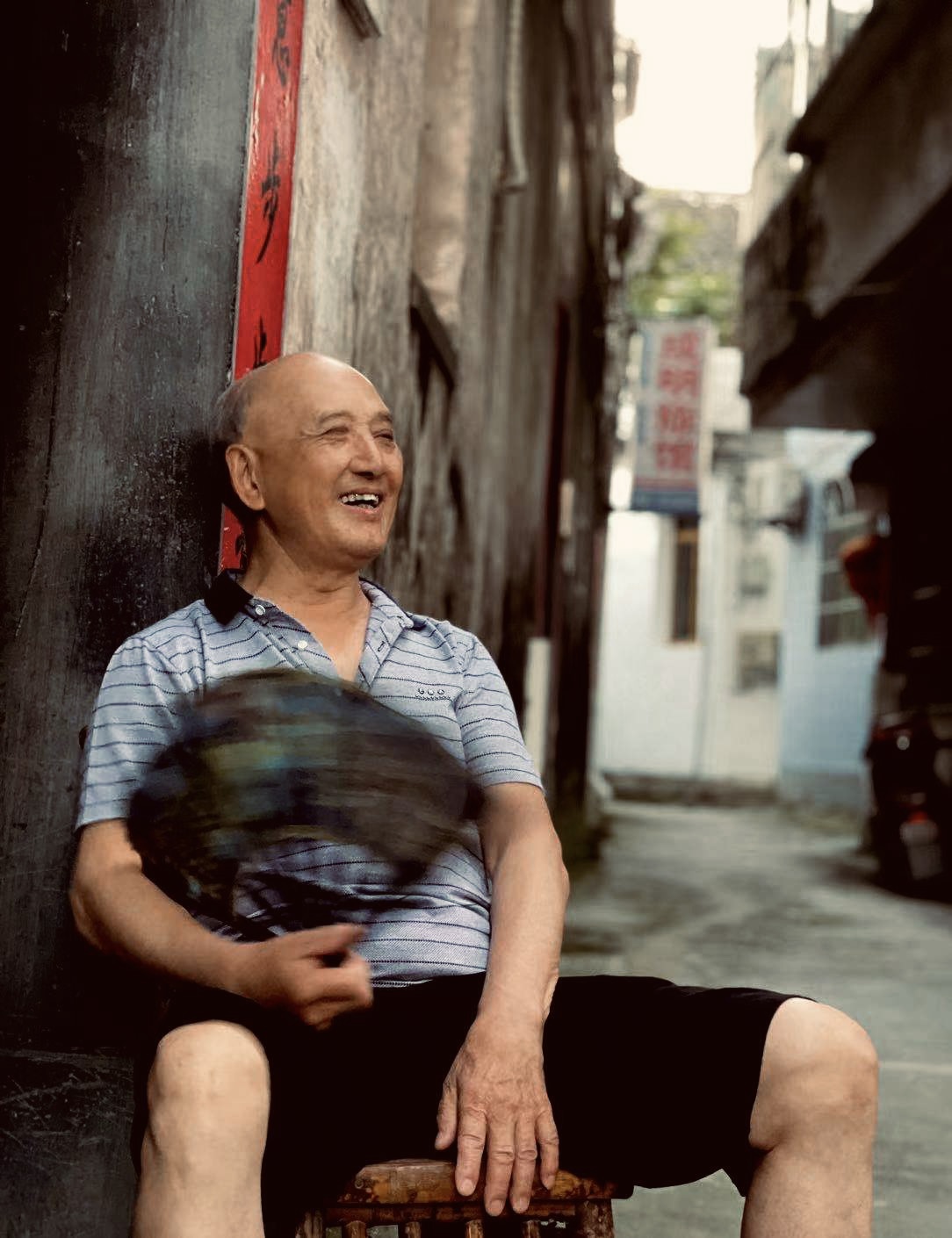 黟县古城郭门街古宅门前摇扇的老人