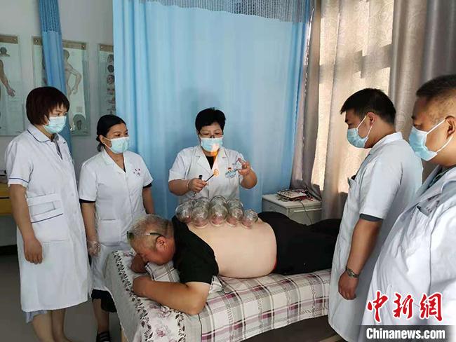 图为冯世霞(左三)正在为患者进行拔罐治疗。(资料图) 受访者供图