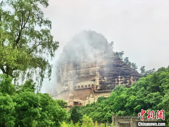 麦积山石窟是中国四大石窟之一，以精美绝伦的泥塑壁画闻名于世，细雨绵绵下的麦积山石窟江南风韵十足。 张婧 摄