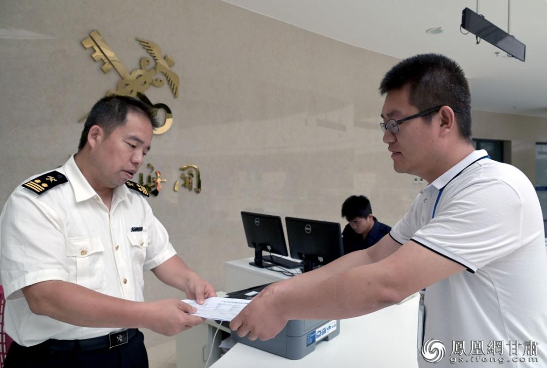 李凯（右）在与海关工作人员对接报关业务 肖刚 摄