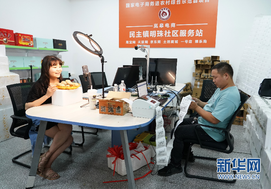 7月6日,安康市岚皋县民主镇明珠社区电商服务中心的工作人员在推介产品、整理物流订单。新华社记者 邵瑞 摄