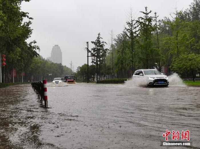 7月20日，河南郑州，车辆从积水路段通过。近日，郑州连遭暴雨袭击，持续强降雨导致部分街头积水严重。 <a target='_blank' href='http://www.chinanews.com/'>中新社</a>记者 李贵刚 摄