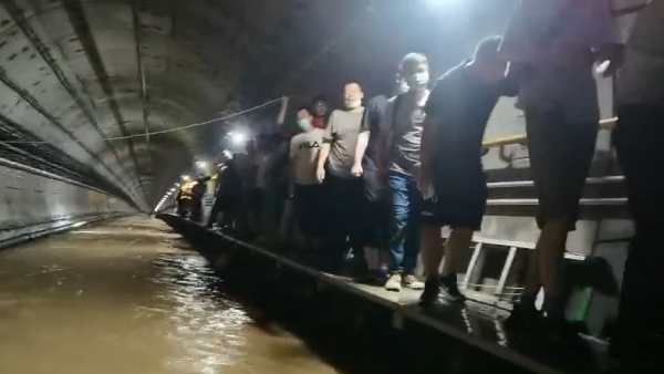 郑州地铁隧道内救援画面：乘客从水中脱身走上沿边小道