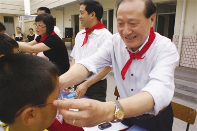 双千光明工程，图为胡德法会长为贫困学生戴上量身定制的近视眼镜。