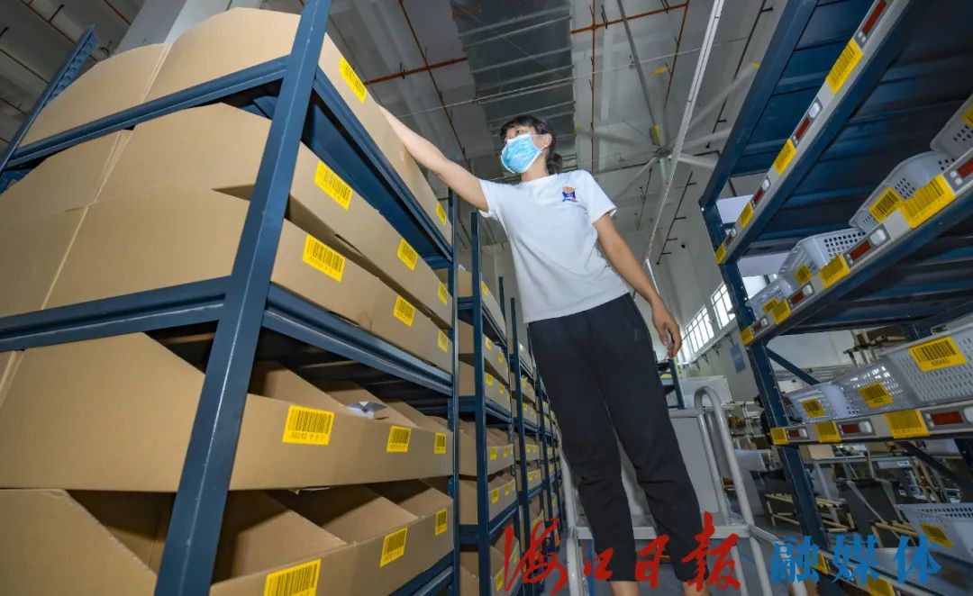 7月28日,在海口综保区内,菜鸟智慧中心仓拣选工作台,工作人员正在分拣