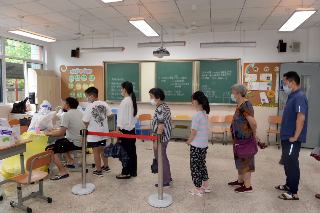 7月25日，在秦淮区的核酸检测点，市民有序排队等待做第二轮核酸检测。