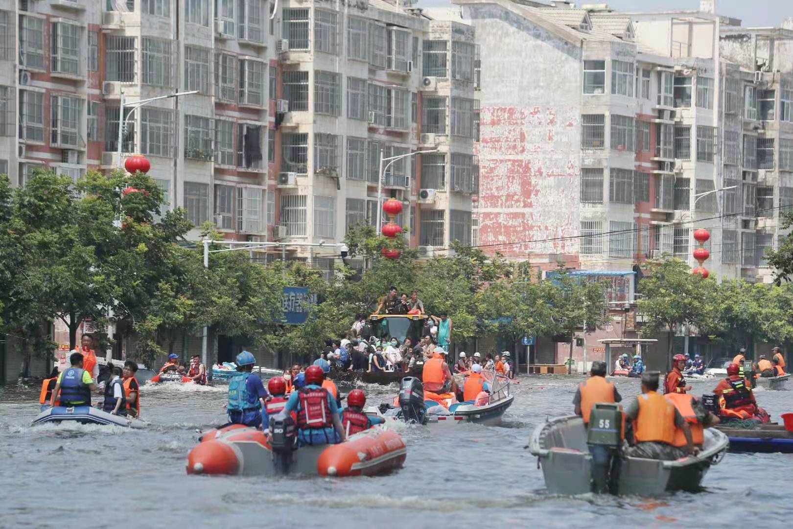 26日下午,医院门口的学院西路上,铲车、冲锋舟在转运人员。新京报记者 王飞 摄
