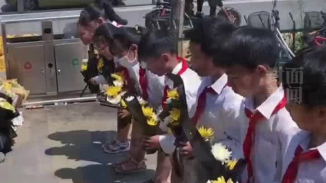 郑州地铁5号线地铁口围栏被拆除 小学生戴红领巾献花吊唁