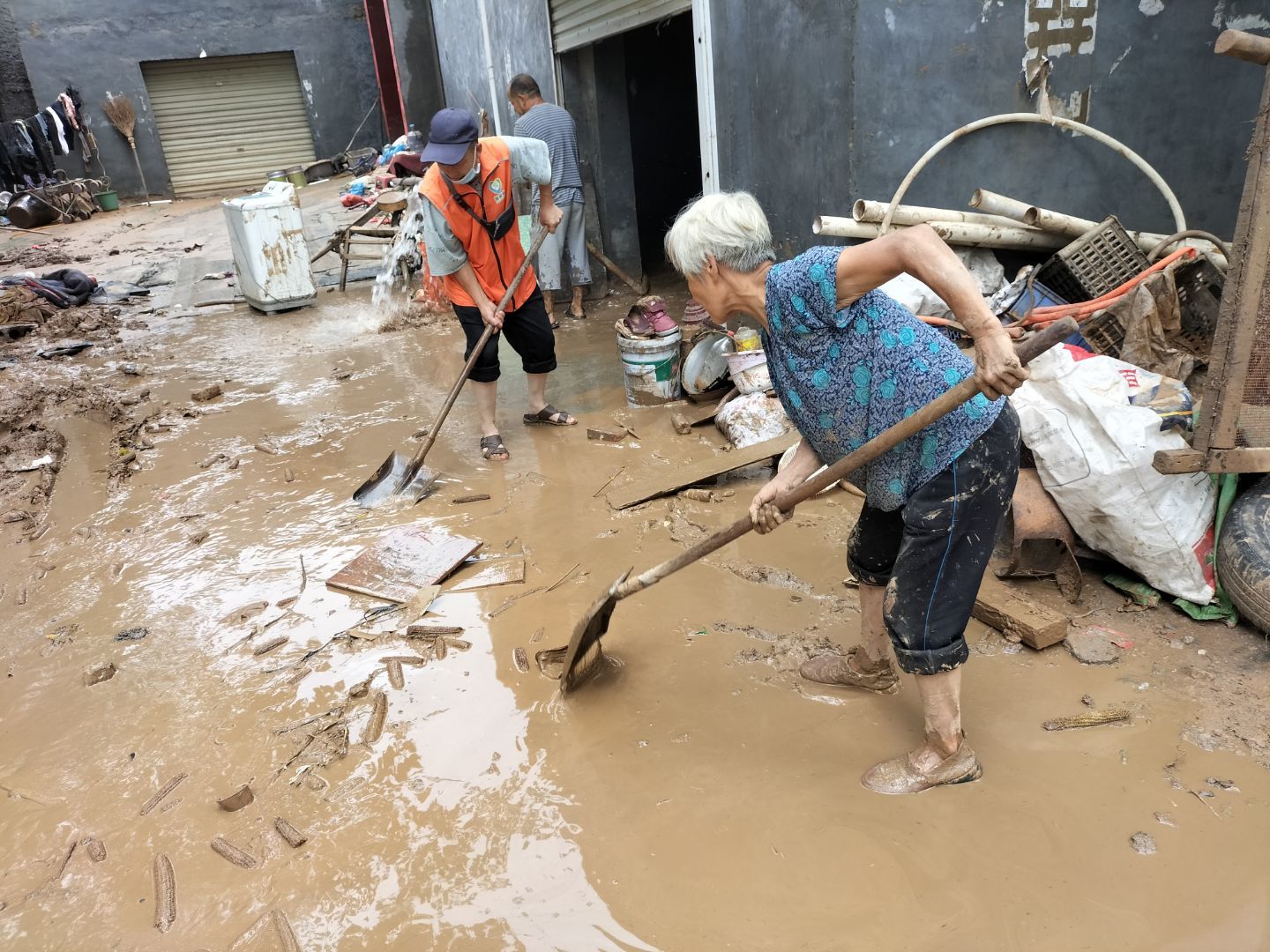 图为清理院内淤泥