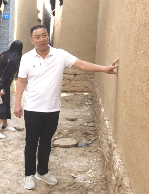赤岸村党支部书记张海魁在红色记忆小镇建设现场展望美好的未来