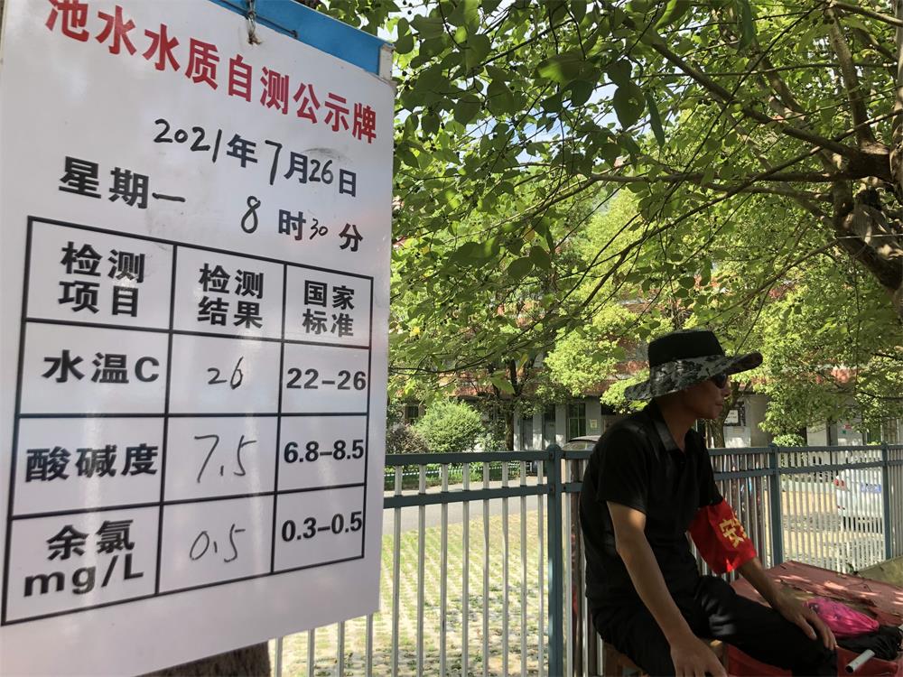 7月26日，罗坊镇希望小学，救生员盯着泳池，旁边的白板用于记录水质。新京报记者 杜寒三 摄