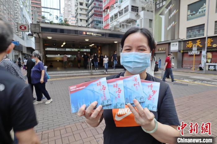 香港地铁湾仔站，市民展示大湾区创新成果明信片。　冯瀚文 摄