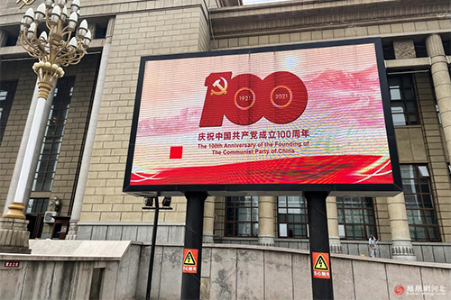 在LED屏幕上，“庆祝中国共产党成立100周年”的标语引人注目。