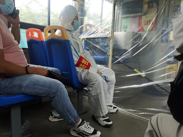 8月1日，下机后的乘客坐公交车前往医院做核酸检测。摄影/章轲