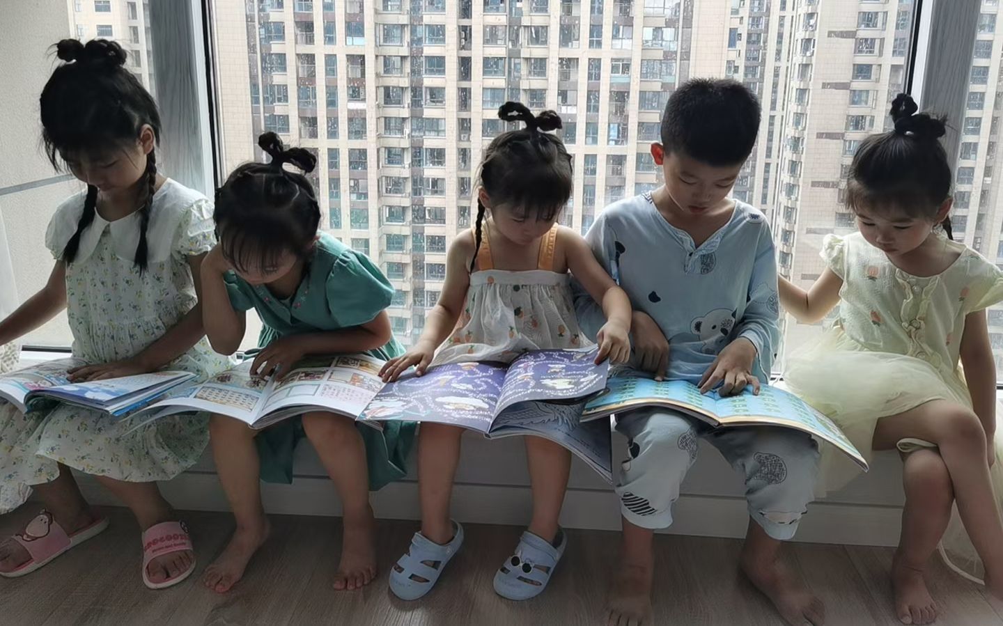 几名两岁到10岁的小朋友被一起居家隔离，年龄大的带年龄小的孩子玩耍、看书。受访者供图