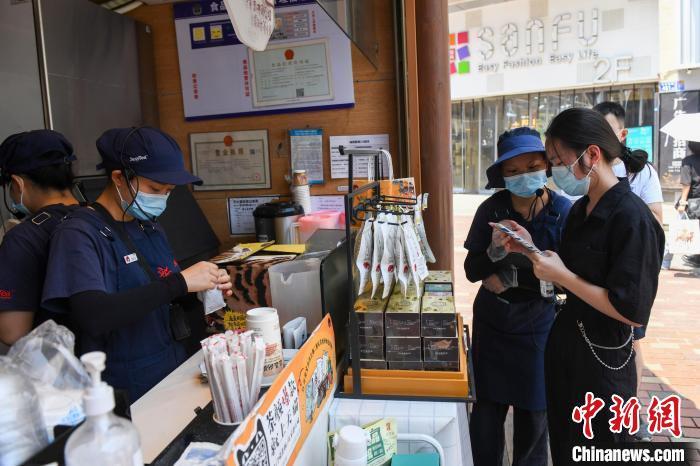 图为一"网红"奶茶店工作人员检验客人的健康码.(资料图) 杨华峰 摄