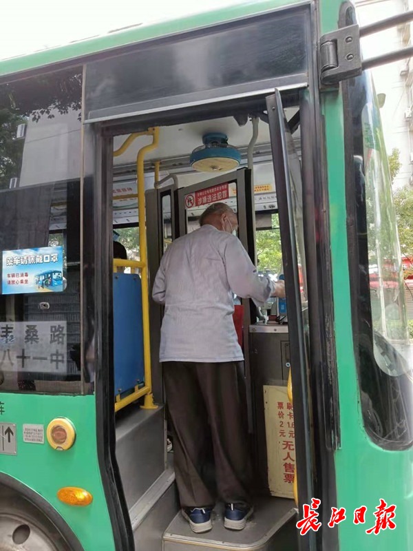 一位老人向司机出示健康证明后，才能刷卡乘车。 长江日报记者李爱华 摄