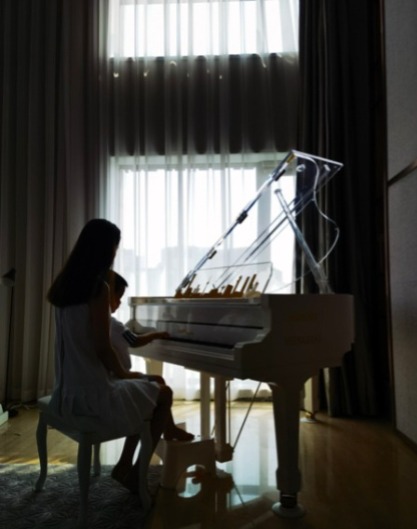 还晒出了儿子朵朵坐在妈妈佟丽娅怀里,母子俩一起弹奏钢琴的背影