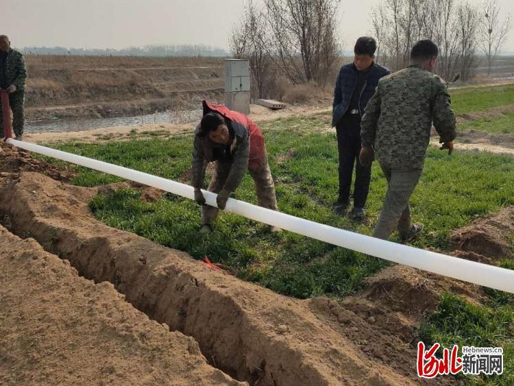 农民在铺节水管。