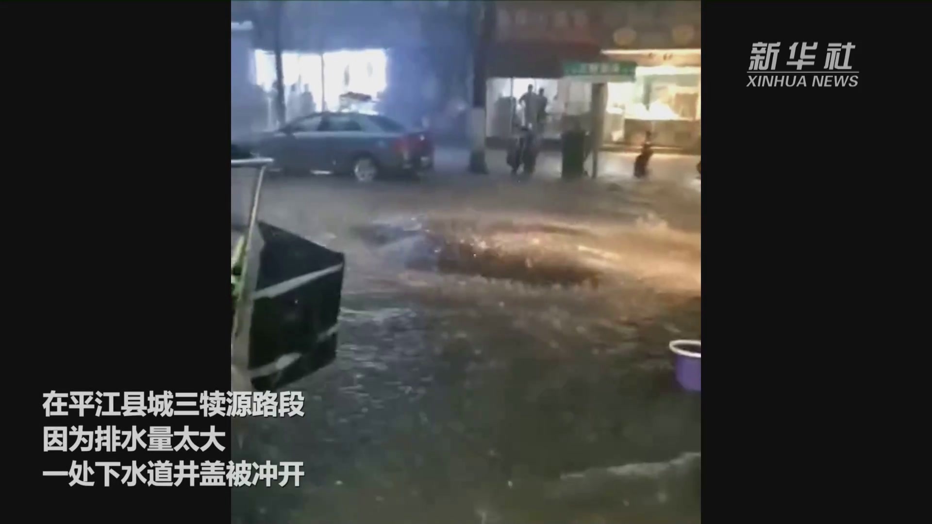 湖南平江：暴雨致城区积水 爱心市民用车挡坑