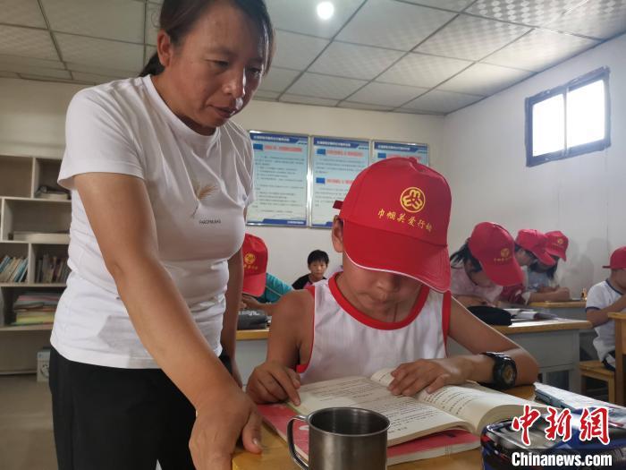 图为王玉红指导留守儿童做作业 受访者供图