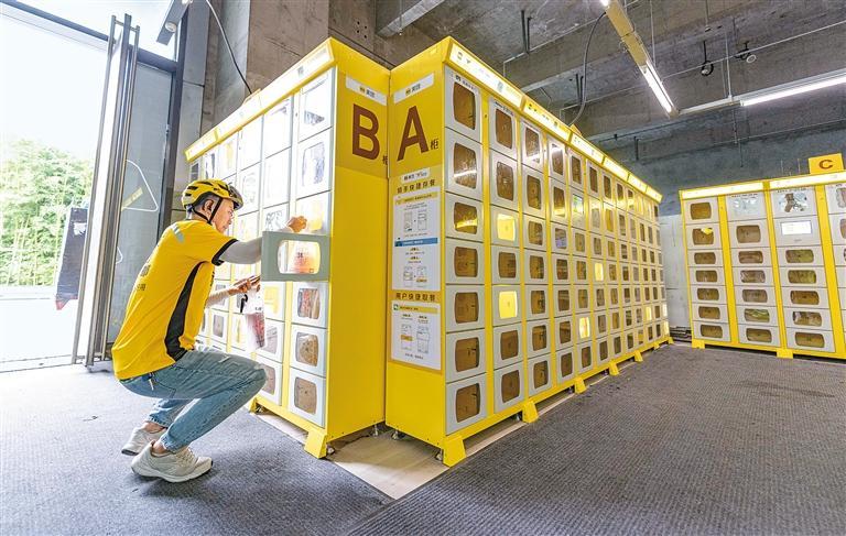 昨日，外卖员在高新区一智能取餐柜内放餐。记者 窦翊明 摄