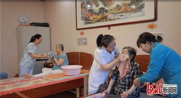 图为在位于古冶区的安馨医疗养老庄园中，医护人员和护工在为老人清洁身体。