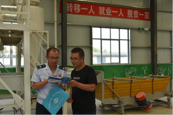 税务干部在西靖镇乾宏供销合作社加工车间宣传政策