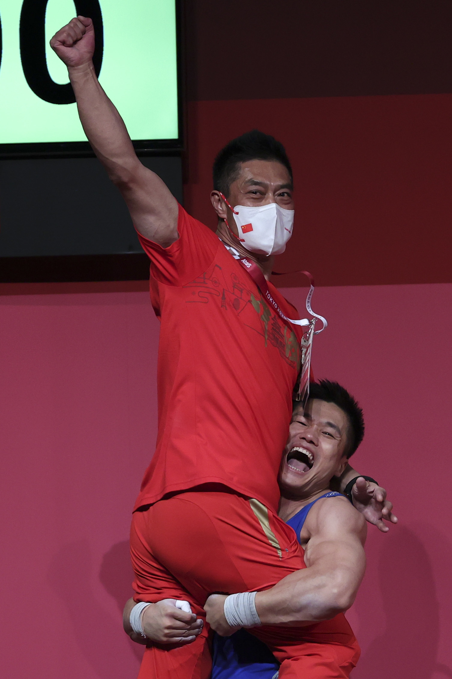 举重名将吕小军夺冠后，一把抱起教练于杰。图/新华社