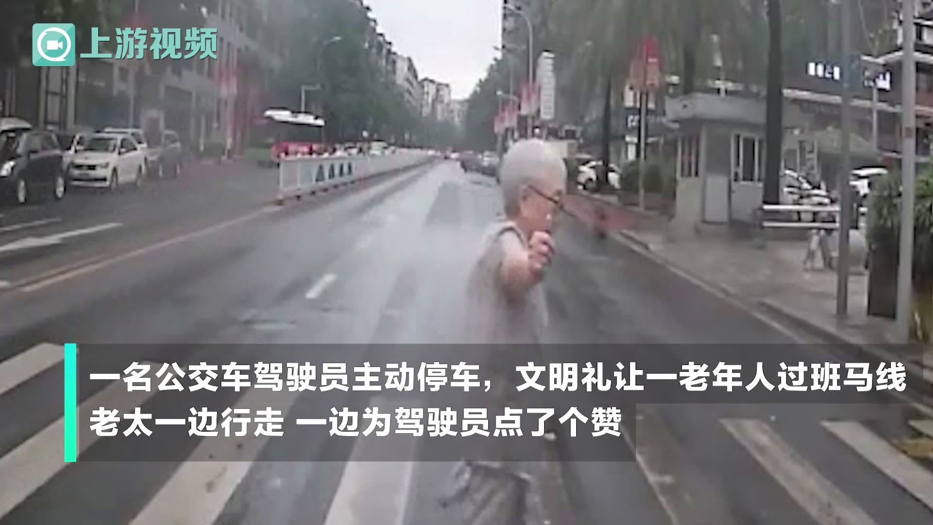 公交车驾驶员斑马线前礼让行人 老人一边过马路一边给他点赞