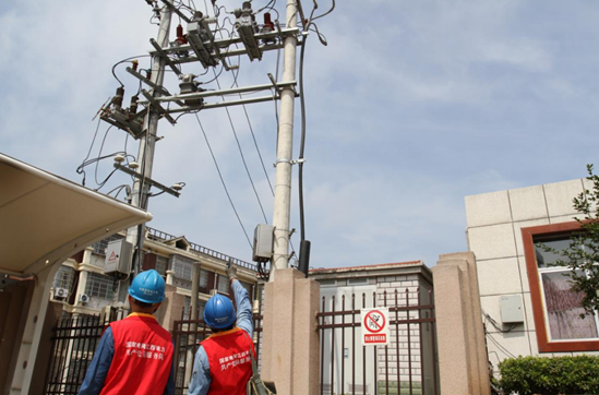国网分宜县供电公司城区供电所共产党员服务队队员在巡视分宜中学高压开关等设备。(彭雪琴 摄)