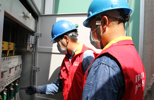 国网分宜县供电公司城区供电所共产党员服务队队员对分宜中学专变低压开关进行检查,并对进线和出线电压进行测量。(彭雪琴 摄)