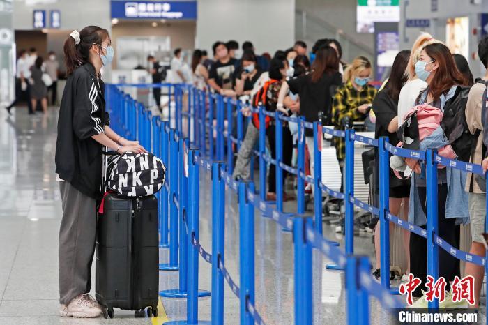 旅客正在等候区内等待办理登机手续。　殷立勤 摄