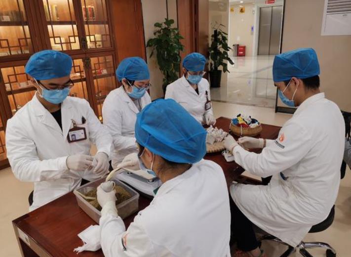 中医医护人员在配制中药。资料图片