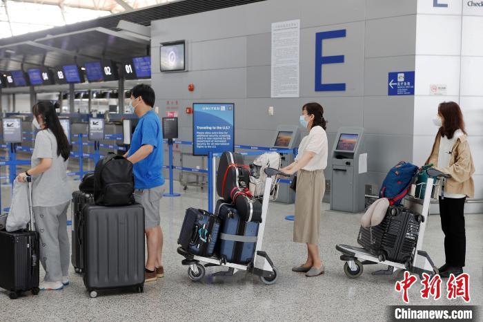 旅客正在等候区内等待办理登机手续。　殷立勤 摄