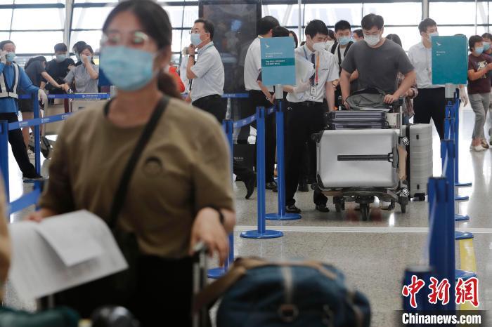 工作人员正在对旅客进行信息核查。　殷立勤 摄