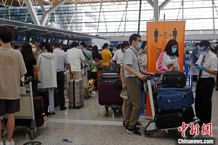 工作人员正在对旅客进行信息核查。　殷立勤 摄