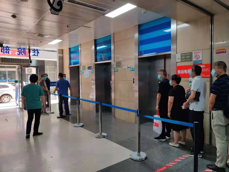 工作人员疏导群众有序乘坐电梯