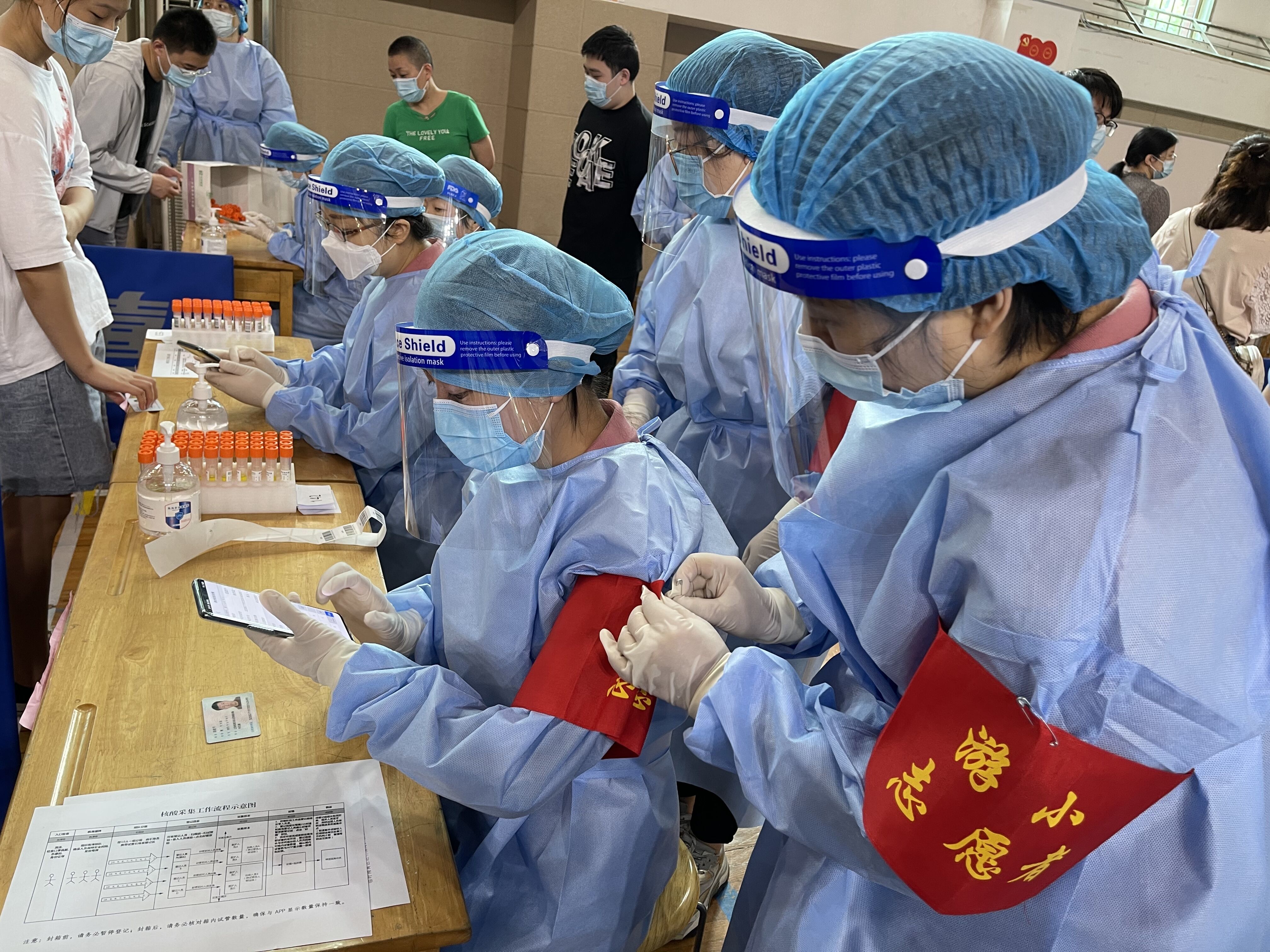 南京市游府西街小学教师志愿者在扫码登记核酸检测信息