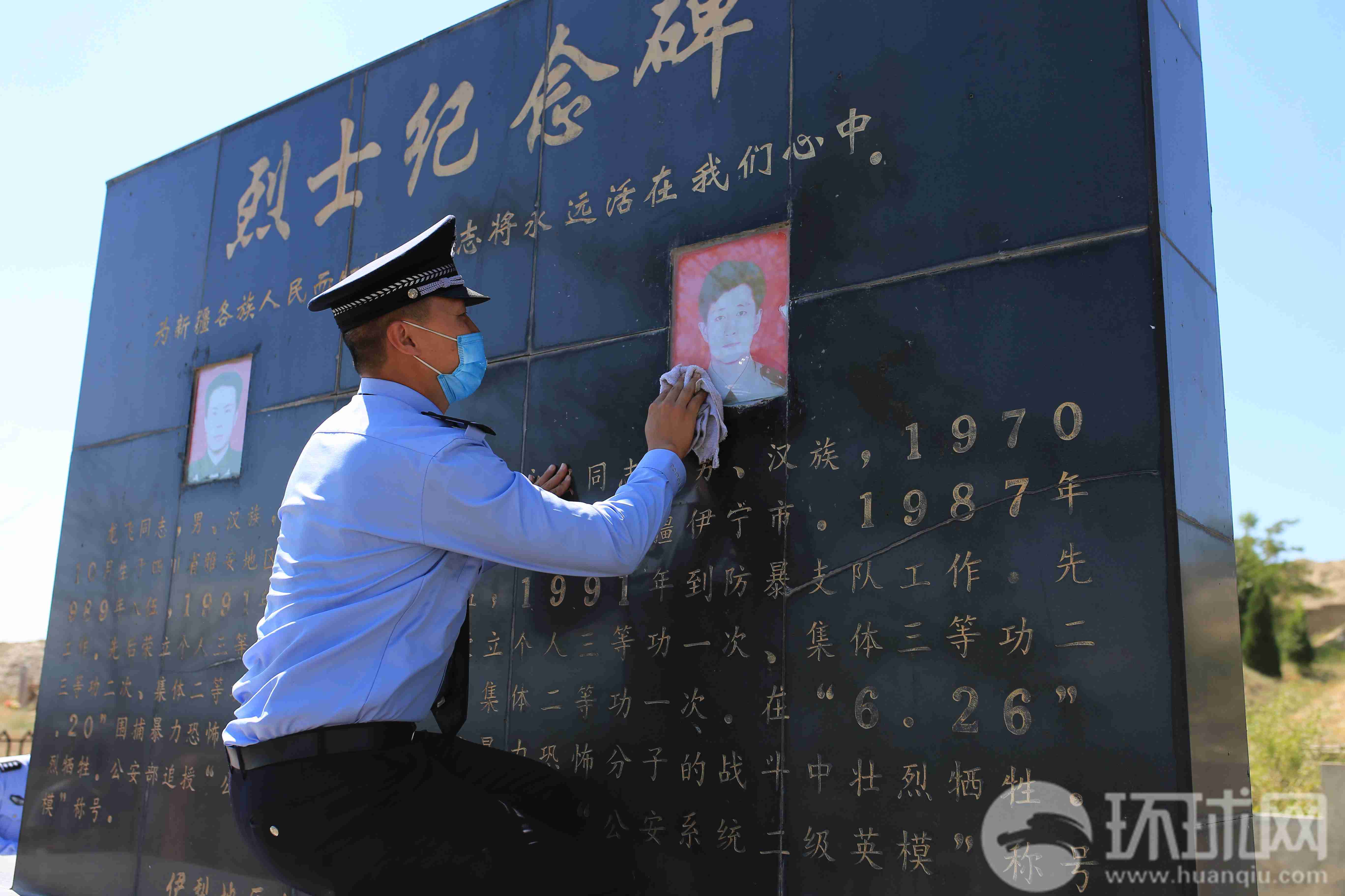 伊犁州公安局的干警在擦拭龙飞和孔永强烈士的纪念碑。摄影 范凌志