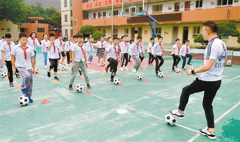 结束了一天的功课,西安育英小学的同学们在操场上练习足球。