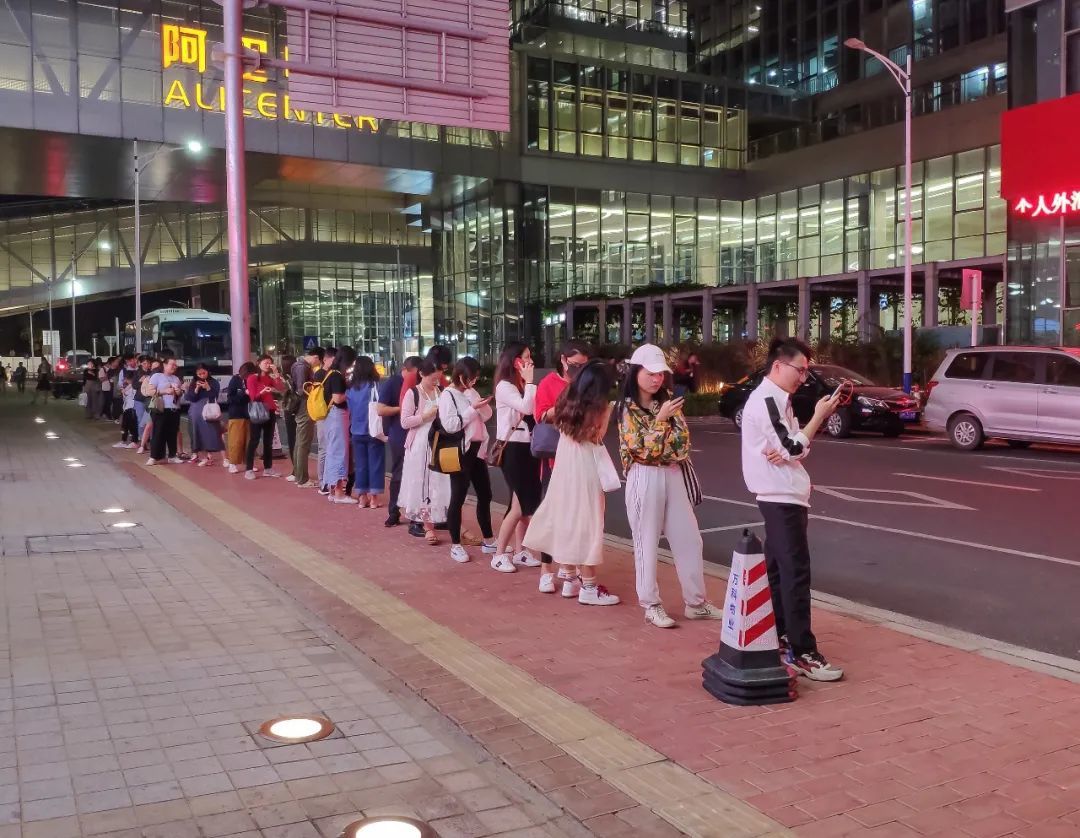 2019年,深圳阿里中心门前,晚上下班的打工人们在排队等班车.