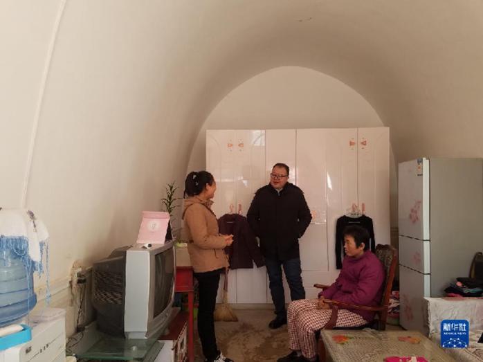 邱军（中）在城壕镇余家砭村村民燕刚家中看望其母亲与妹妹（2018年12月11日摄）新华社发（华池县委宣传部供图）