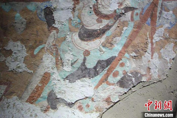 李晓洋与爷爷李云鹤对莫高窟遭遇地仗酥碱病害的壁画进行修复.